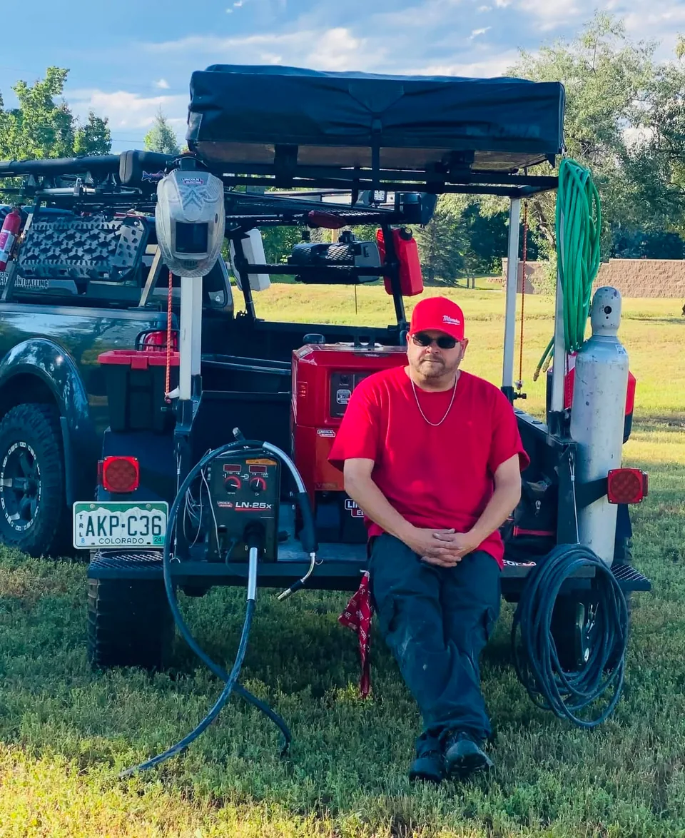 Jake Zink seated in front of his mobile welding setup